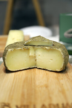 queso artesanal de cabra con costra de especias en una tabla de madera