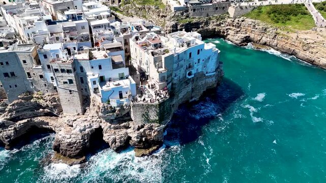 Polignano a Mare with Lama Monachile beach. Aerial 4K drone video footage with panorama view of stunning coastal townscape in Puglia, southern Italy