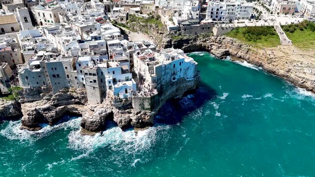 Polignano a Mare with Lama Monachile beach. Aerial 4K drone video footage with panorama view of stunning coastal townscape in Puglia, southern Italy