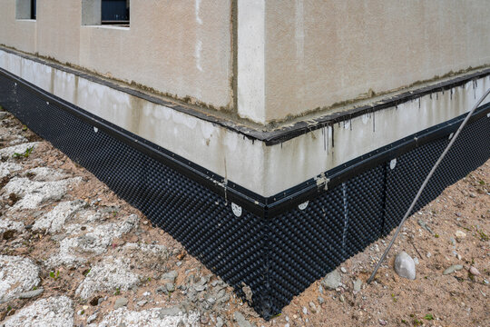 Foundation waterproofing membrane installed on modern residential building under construction site