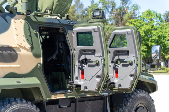 A camouflaged modern 4x4 MRAP armored fighting vehicle with open doors