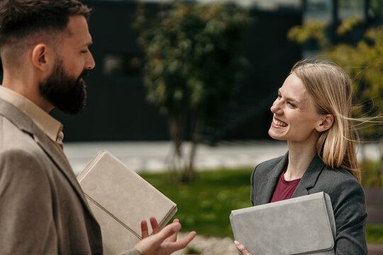 Business professionals having outdoor discussion and smiling
