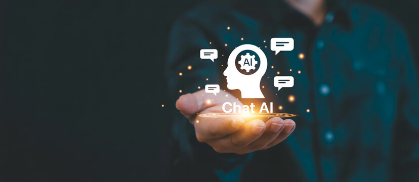 Artificial intelligence chatbot concept showing human hand presenting glowing profile head icon with gear symbol and speech bubbles for virtual assistant interaction.