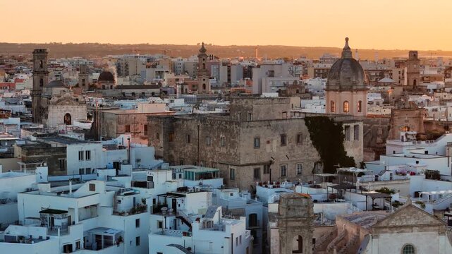 Aerial 4K drone video footage with panorama view of Monopoli Old Town at sunset, scenic Adriatic sea coastal cityscape in Puglia with historic Italian architecture