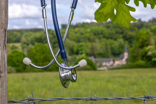 Stethoscope Hanging on a Fence by a Field-The concept of a medical desert, a shortage of rural doctors