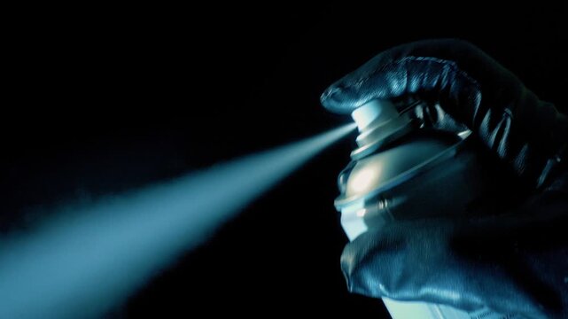 Person Sprays Can With Gloves On