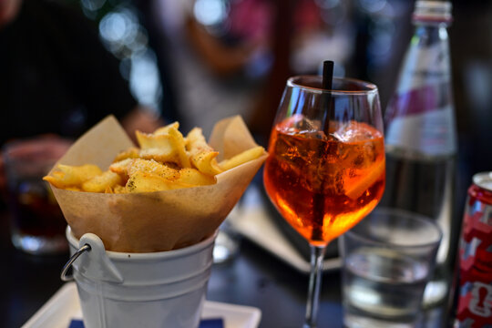 Aperol Spritz and ,cacio e pepe fried  potatoes tipical italian snack for aperitivo in a bar in ,Rome, Italy