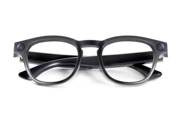 Front view of sleek black smart glasses with transparent lenses and integrated cameras isolated on white background © amedeoemaja