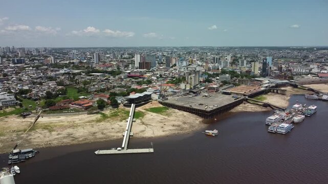 Drone Manaus-Brazil Aerial view of a bustling port city with modern buildings and a wide river under a clear blue sky city