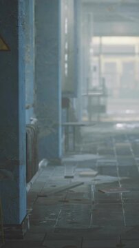 An empty corridor in a neglected building shows peeling blue walls and scattered debris on the floor. Sunlight filters through dusty windows, revealing the state of disrepair.