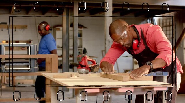Carpenter inspecting clamped frame, sanding and aligning ensuring fit while viewfinder grid marking