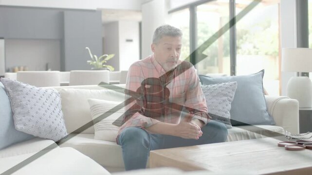 Mature man on sofa leaning adjusting hands as clock sweeping, implying health reflection