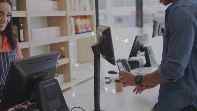 Male customer tapping smartphone at cafe counter to complete purchase, cashier operating POS screen