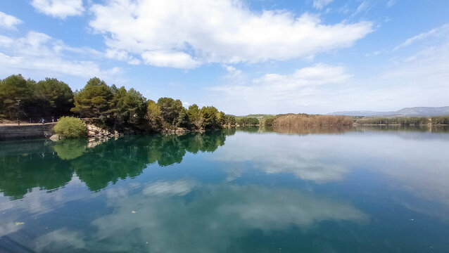 Regajo reservoir reflection with green pine forest in Castellon Spain