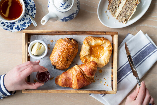 Enjoying a Delightful Breakfast Spread With Pastries and Tea in a Cozy Setting