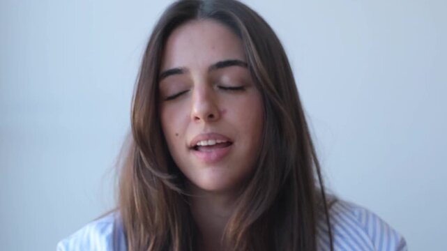 A confident and articulate young woman speaks directly to the camera, sharing her thoughts and insights with a serious, focused expression.