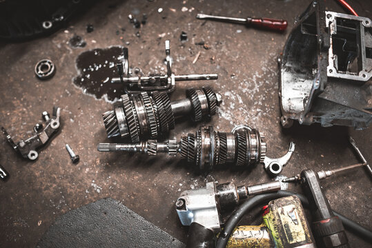 Automotive transmission gears and tools laid out on a messy workbench