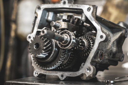 Close-up view of a disassembled manual transmission gearbox with visible gears and bearings