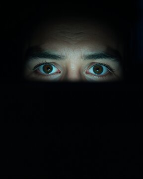 Close-Up Of Tired Eyes Reflected In Laptop Screen Glow