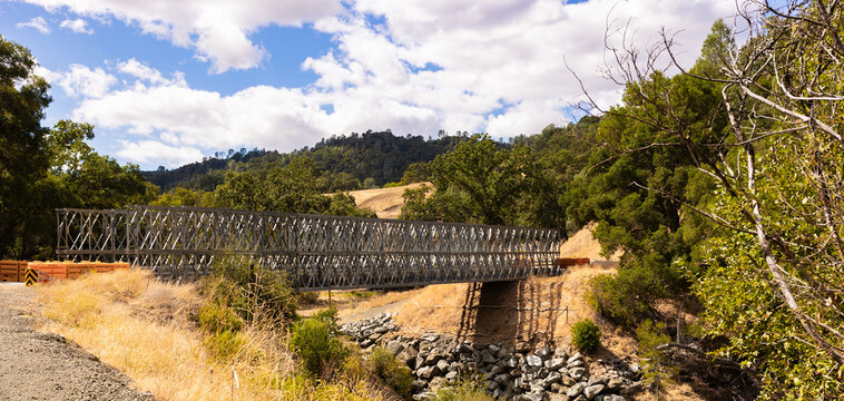 Temporary steel truss modular bridge installed over a rural creek washout