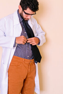 Professor scientist in lab coat getting ready for lab class. Doctor in white lab coat and striped shirt. Bearded man. Chemistry teacher