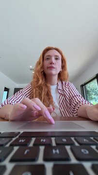 A young woman works on her laptop at home, then celebrates with joy after achieving success.