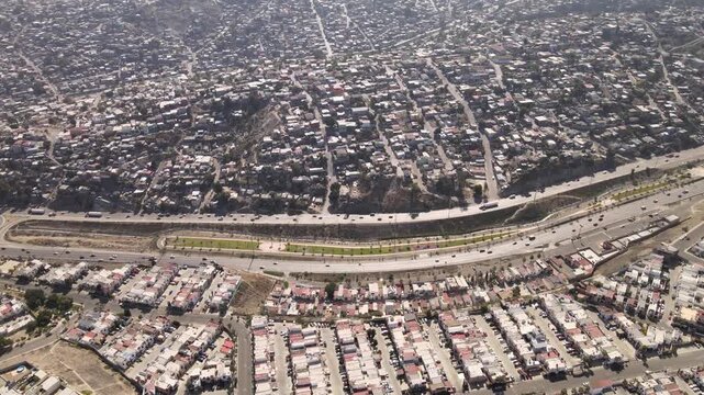Vista a&eacute;rea panor&aacute;mica de v&iacute;a r&aacute;pida y divisi&oacute;n de zonas residenciales en los cerros de Tijuana, Baja California, M&eacute;xico