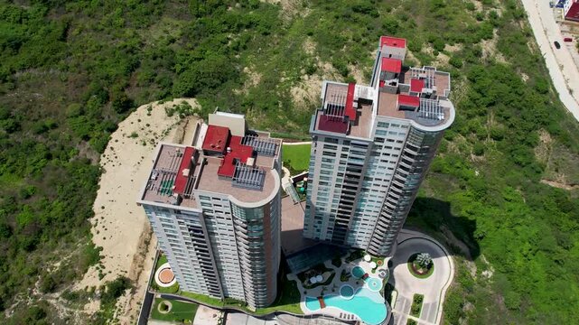 Top down aerial drone view of luxury residential building rooftops and swimming pool