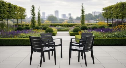 Fototapeta premium Symmetrical modern chairs on an urban terrace overlooking a landscaped garden with city skyline