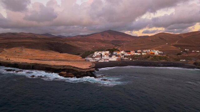 Aerial view of Ajuy village in sunset, which is a region and hamlet in the municipality of Pajara on the island of Fuerteventura, Canary Islands, Spain. Drone POV exploration of Fuerteventura Island. 
