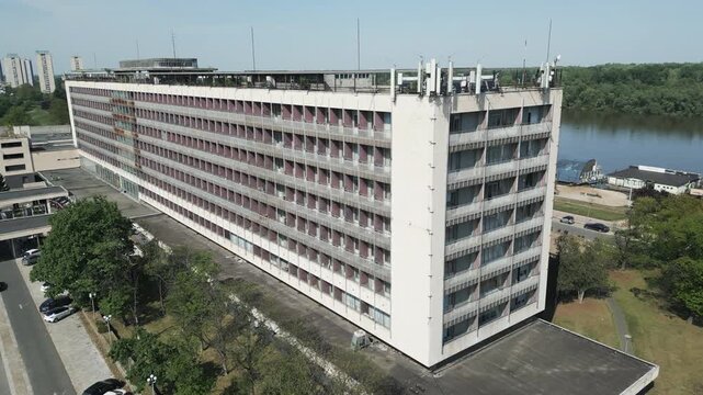 Slow drone backward flight revealing the massive brutalist architecture of an abandoned socialist era hotel in Belgrade, Serbia.