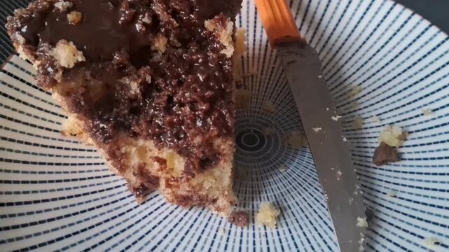 Delicious slice of chocolate cake on a patterned plate with a metal knife for dessert