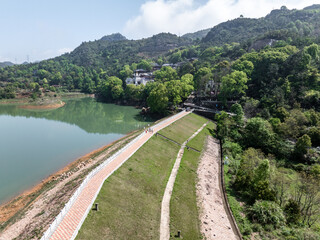 Fototapeta premium Reservoir dam and embankment surrounded by green mountains and clear water landscape