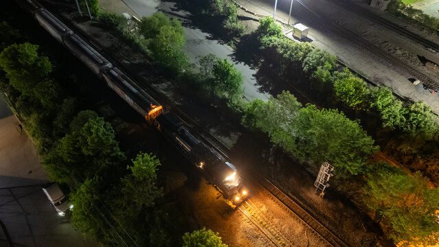 Aerial view of freight train moving on tracks night city