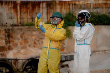 Obraz premium Environmental hazard and industrial pollution investigation concept. Hazmat team inspecting contaminated water near industrial gas storage facility and drainage canal