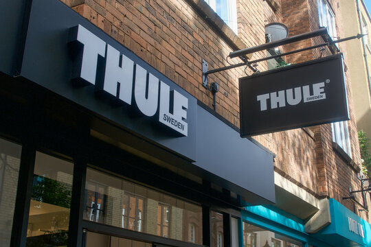 Low-angle view of the official Thule Sweden brand signage and hanging banner on the facade of a retail store