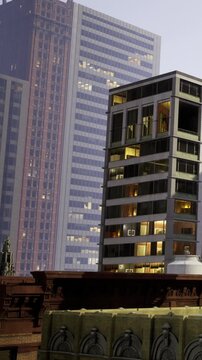 Tall buildings stand close together in the city at night. Some windows are lit, suggesting people are inside. The view captures urban life and architecture in a bustling area.