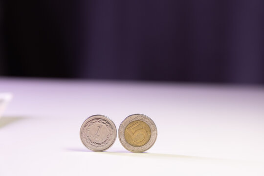 Polish coins rolling on a white table, money and finance concept.