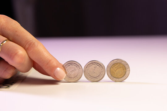 Polish coins rolling on a white table, money and finance concept.
