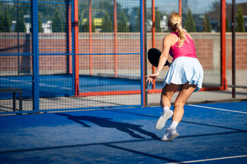 Obraz premium Woman playing padel on outdoor court