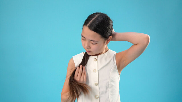 Prety young asian girl playing with her long dark hair