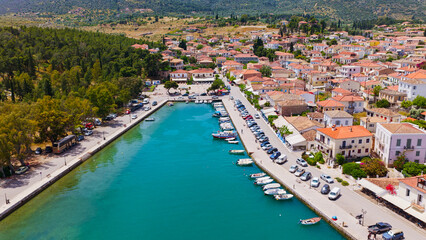 Obraz premium Aerial view showcasing the picturesque coastal town of galaxidi in peloponnese, greece, featuring its charming marina filled with boats and traditional architecture along the waterfront