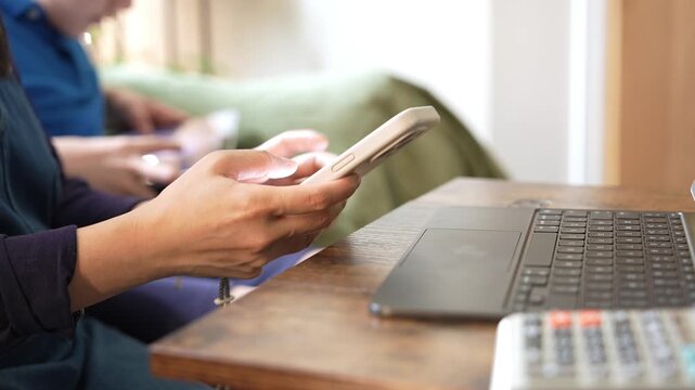 Mother working on smartphone and laptop at home while son playing video games, remote work, digital parenting, family lifestyle and work life balance concept,Mother and son spending time together