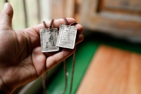 Traditional Catholic brown scapular held in hand
