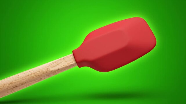 Red Silicone Spatula with Wooden Handle Rotating on Green Screen Background.