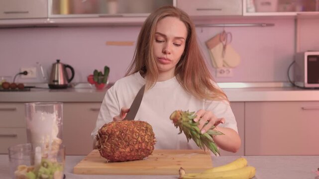 Closeup of pineapple slicing process. Hands expertly cutting pineapple into rings. Closeup footage showcasing detailed process of preparing fresh pineapple for cooking