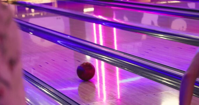 Bowling club play, group team of friends and colleagues playing, throwing a ball on the bowling alley lane, ball and pins, corporate party event in a mall amusement game center, tournament competition
