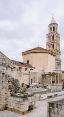 Obraz premium Ancient stone structures and a majestic bell tower define the historic Diocletian's Palace in Split, Croatia, under a softly lit sky