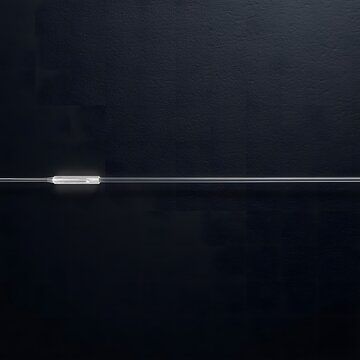A cut optical fiber strand on black slate &mdash; the glowing tip from internal light reflection makes this a quiet, sharp image of severed data transmission.