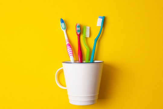 Minimalist Composition Featuring Toothbrushes And Toothpaste In Clean Studio Setting With Vibrant Colors